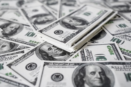 A stack of money. Heap of one hundred dollar bills on money background. Fake money. Shallow depth of...