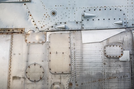 Abstract metal background. Old weathered silver metallic background. Vintage metal texture with rivets and bolts. Sheathing old plane. Old metal texture.の写真素材