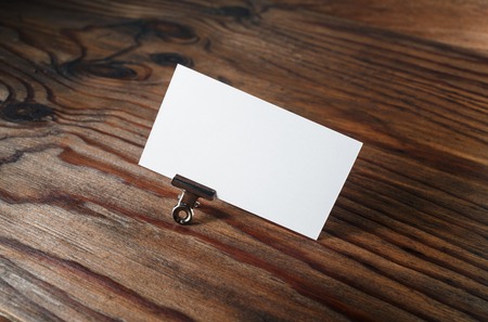 Photo of blank business card on vintage wooden background. Blank white business card. Mockup for branding identity. Blank ID template.の写真素材