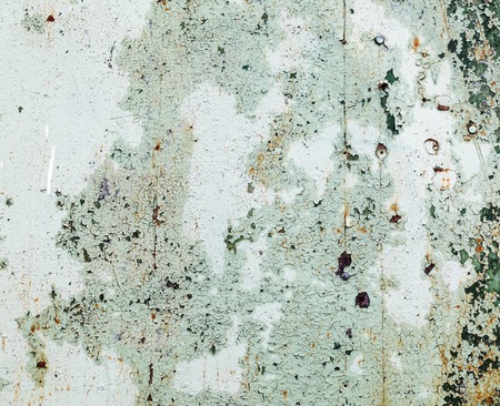 Background of old peeling paint with cracks and scratches. Weathered peeling paint texture.の写真素材