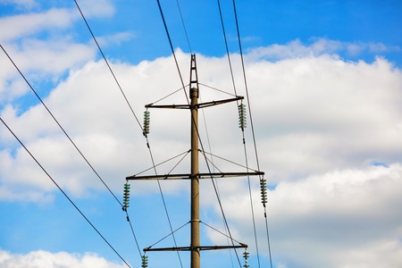 Old power lines. Electricity transmission pylon against the blue sky. High voltage tower.の写真素材