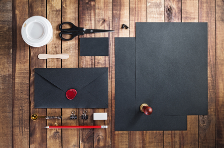 Photo of blank black stationery set on vintage wooden table background. Template for placing your design. Mockup for branding identity. Top view.の写真素材