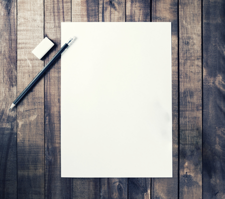 Photo of blank stationery: letterhead, pencil and eraser on vintage wooden table background. Responsive design mockup for placing your design. Top view.の写真素材