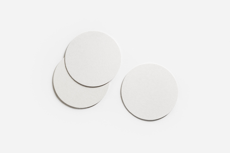 Three blank white beer coasters on paper background. Responsive design mockup. Flat lay.の写真素材