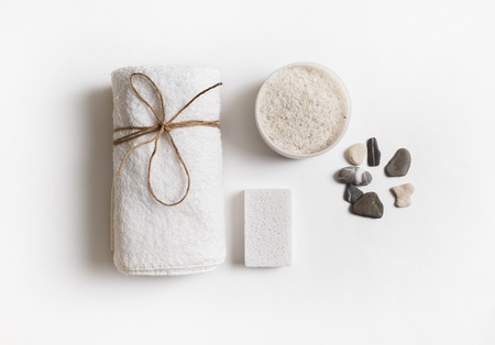 Beauty and spa concept. Towel, sea salt, pumice and stones on white paper background. Flat lay.の写真素材