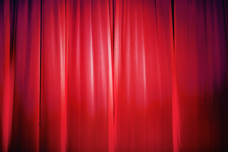 Bright red stage curtain with spotlight. Abstract background.の写真素材
