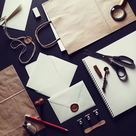 Blank stationery set on black paper background. Template for branding identity. Vintage toned image. Top view.の写真素材