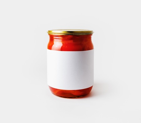 Red paprika canned in a jar with blank label. Pickled vegetables. Responsive design mockup.の写真素材