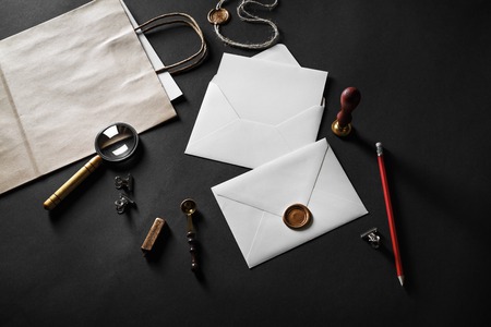 Blank paper envelopes and stationery on black paper background. Responsive design mockup.の写真素材