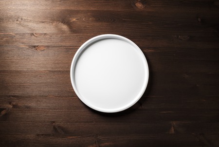 Blank white plate on wooden background. Flat lay.の写真素材