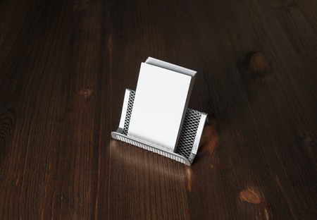 Blank business cards on metal holder at wood table background.の写真素材
