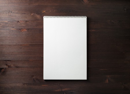 Blank spiral sketchbook on wood table background. Responsive design template. Space for text. Flat lay.の写真素材
