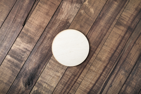 Blank wooden beer coaster on wood table background. Flat lay.の写真素材