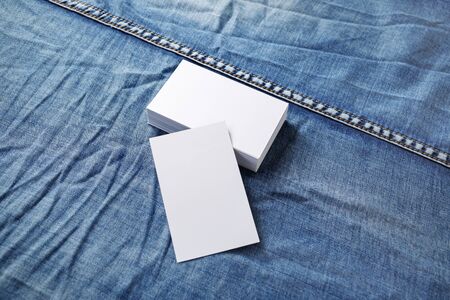 Photo of blank white business cards on denim background. Template for ID.