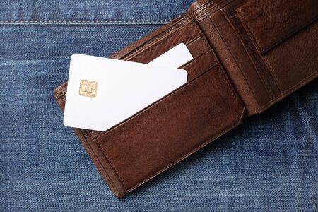 Blank white credit cards in leather wallet on denim background. Flat lay.の写真素材