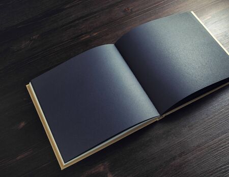 Photo of blank black brochure mock up on dark wood table background. Copy space for text.の写真素材