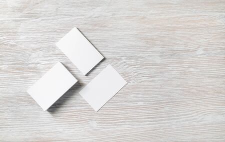 Photo of blank business cards on light wooden background. Template for ID. Copy space for text. Flat...