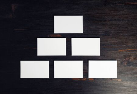 Blank business cards on wood table background. Mockup for branding identity. Flat lay.の写真素材