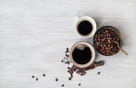 Photo of coffee cups and coffee beans on light wooden background. Copy space for your text. Top view. Flat lay.の写真素材