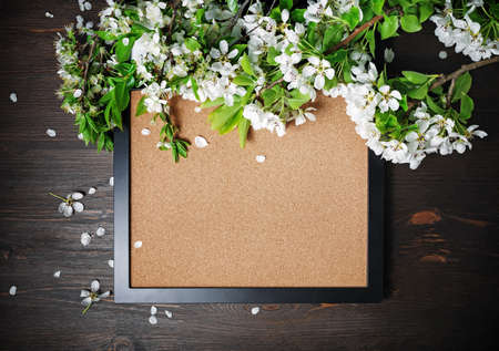 Poster or photo frame and spring flowers on wood table background. Flat lay.の写真素材