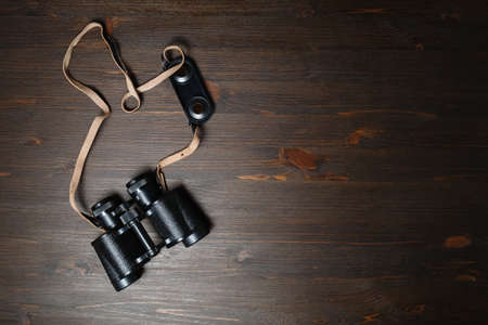 Old black military binocular on wood table background. Copy space for your text. Flat lay.の写真素材