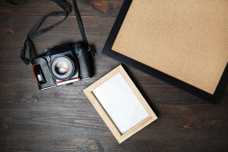 Retro camera and blank photo frames on wooden background. Responsive design mockup. Top view. Flat lay.の写真素材