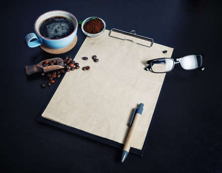 Stationery set and coffee. Clipboard with blank kraft paper, coffee cup, coffee beans, pen, glasses...