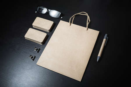 Blank kraft stationery and corporate identity template on black wood background. Responsive design mockup.の写真素材