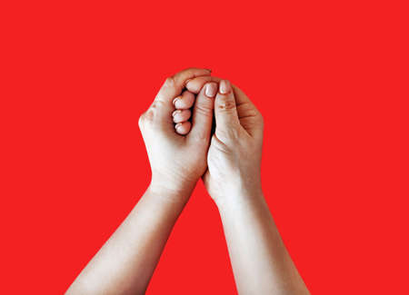 Hand in hand. Female hands depict washing on red background.の写真素材