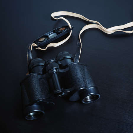 Vintage black binocular on black wooden background.の写真素材
