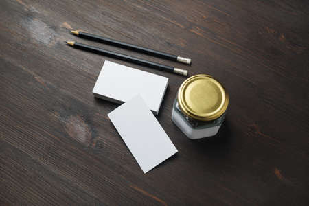 Blank business cards, pencils and jar on wooden background. ID mockup. Responsive design template.の写真素材