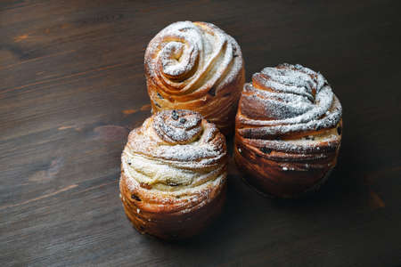 Three sweet buns on wood table background.の写真素材