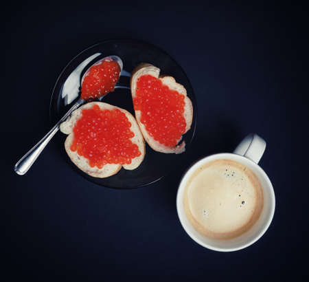 Coffee cup, sandwiches with red caviar and spoon. Flat lay.の写真素材