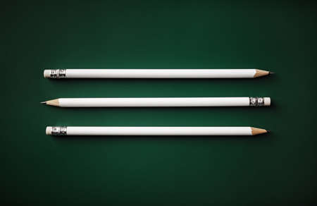 Three white pencils with copy space on green background. Flat lay.の写真素材