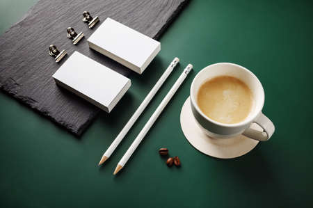 Blank stationery and coffee cup on green background.の写真素材