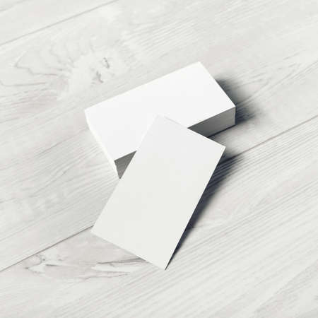 Blank white business cards on light wooden background. Mockup for ID. Template for graphic designers portfolios.の写真素材