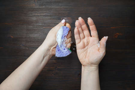 Sponge for washing and cleaning in female hands.の写真素材
