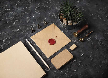 brand identity mockup. Blank kraft stationery set on black plaster background.