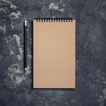 Photo of blank kraft notebook and pencil on concrete background. top view. flat lay.の写真素材