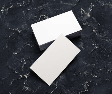 Blank business cards on black plaster background. Mockup for branding identity.の写真素材