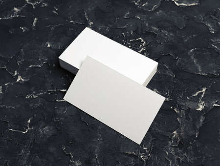 Blank white business cards on black plaster background. Mockup for branding identity.の写真素材