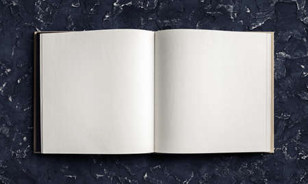Blank opened booklet on black plaster background. Responsive design template. top view. flat lay.の写真素材