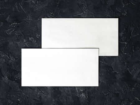 Two blank envelopes mockup on black plaster background. Template for branding identity. top view.の写真素材
