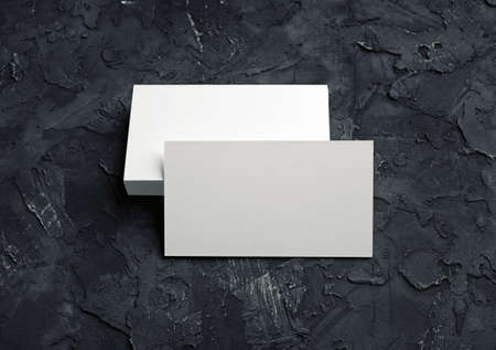 Photo of blank business cards on black plaster background. Mock-up for branding identity for designers.の写真素材