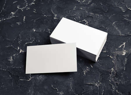 Photo of blank business cards on black plaster background. Template for ID. Mockup for branding identity.の写真素材