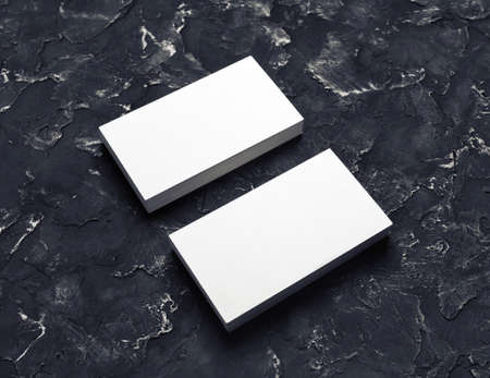 Photo of blank business cards on black plaster background. Mock-up for branding identity for designers.の写真素材