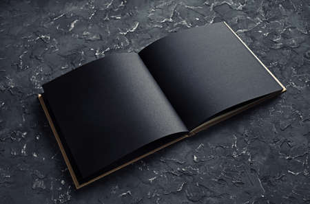 Blank black opened brochure on black plaster background. Mock-up for graphic designers portfolios.の写真素材
