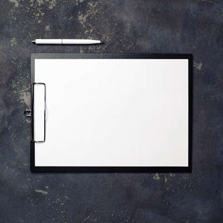 Clipboard with blank paper and pen on concrete background. top view.の写真素材