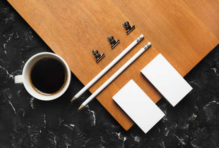 Photo of blank stationery set and coffee cup on wooden board background. corporate identity template. flat layの写真素材