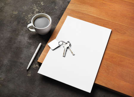 Real estate paperwork concept. Blank letterhead, key, coffee cup and pen.の写真素材